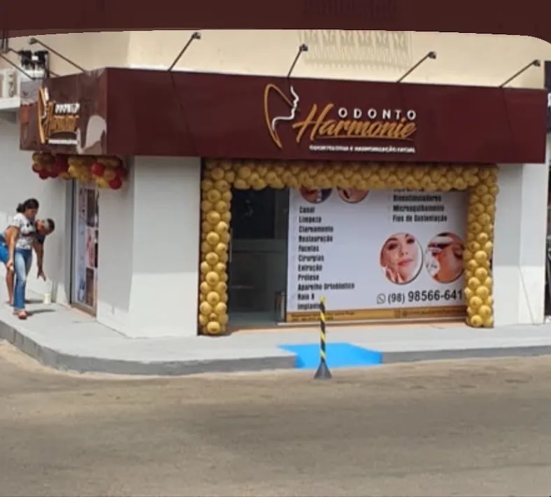 Fachada bordô da Odonto Harmonie com o logo dourado