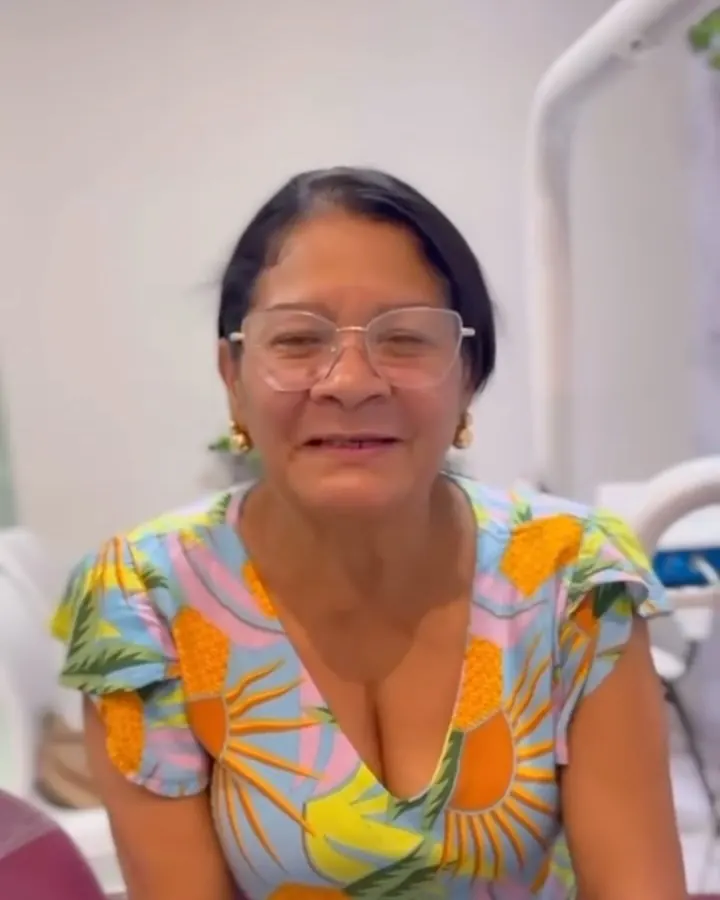 Paciente de prótese sorrindo no consultório